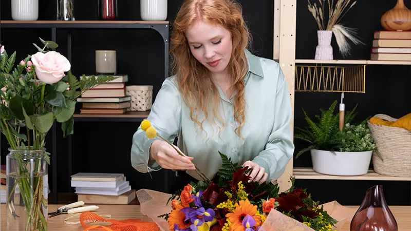 Mulher fazendo arranjo para decoração de mesa de centro